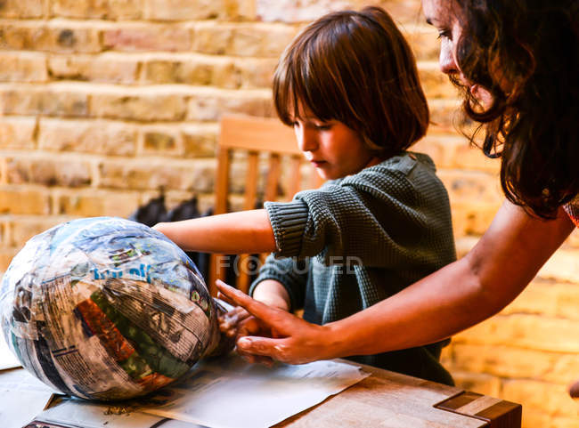 Child and mother playing with papier mache — Stock Photo