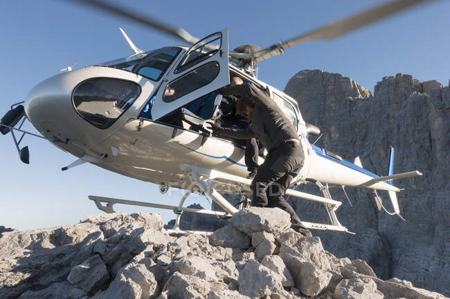 BASE jumping team in uscita dall'elicottero in alta quota a Torre Trieste, Alpi italiane, Alleghe, Belluno, Italia — Foto stock