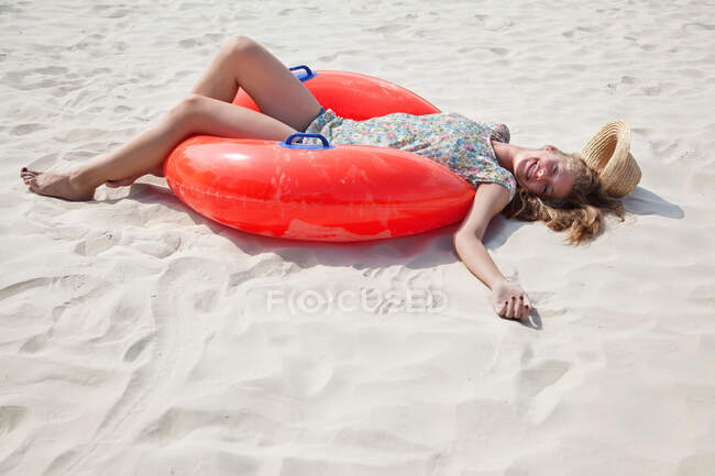 Красива жінка лежить на піску посміхається — стокове фото