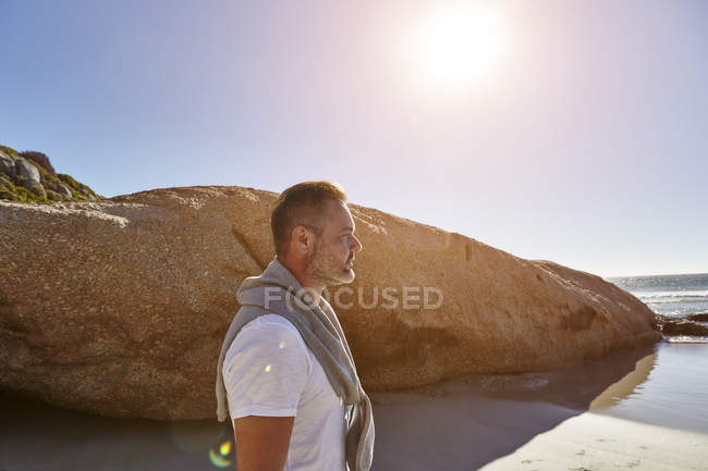 Hombre maduro de pie en la playa, mirando a la vista, Ciudad del Cabo, Sudáfrica - foto de stock