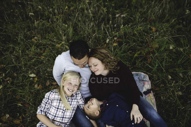 Вид сверху на семью, лежащую вместе на траве — стоковое фото