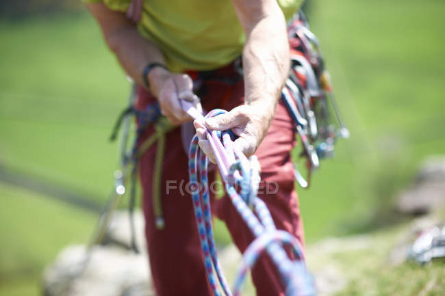 Vista recortada del escalador sosteniendo la cuerda de escalada - foto de stock