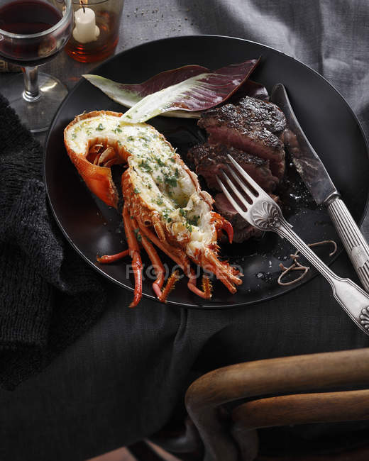 Lobster and steak served on plate with cutlery — Stock Photo