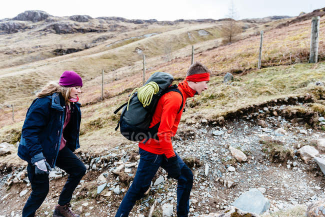 Parejas jóvenes senderismo, Honister Slate Mine, Keswick, Lake District, Cumbria, Reino Unido - foto de stock
