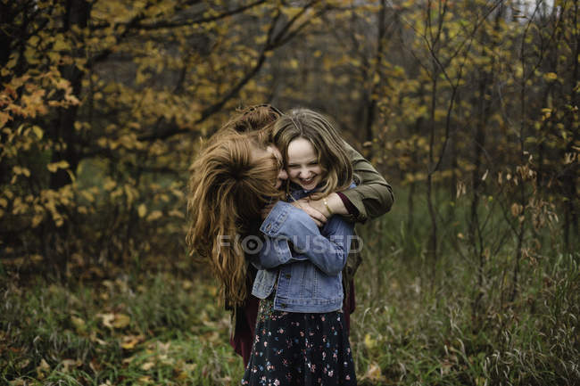 Mother and daughter hugging in wooded area, Lakefield, Ontario, Canada — Stock Photo