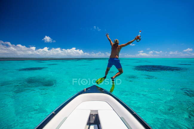 Reifer Mann mit Schwimmflossen springt vom Boot, Ile aux Cerfs, Mauritius — Stockfoto