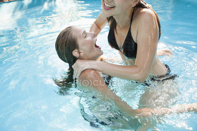 Duas adolescentes pulando na piscina — Fotografia de Stock
