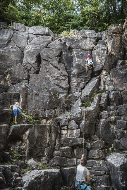 Familie klettert an Felswand — Stockfoto
