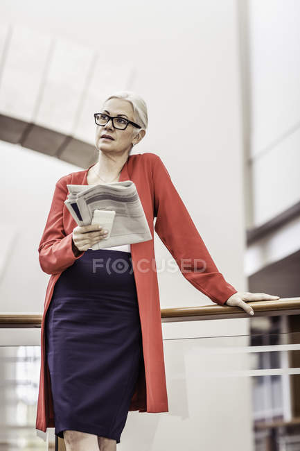 Donna d'affari che legge giornale sul balcone dell'ufficio — Foto stock