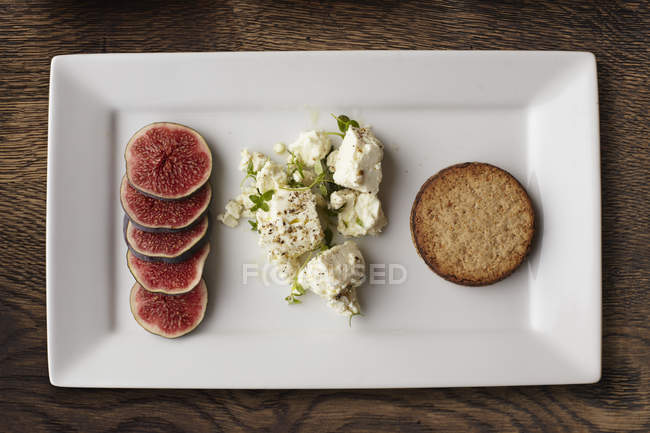 Top view of feta, fig slices and cracker on plate — Stock Photo