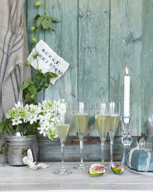 Champagne con regalo di Natale e candela accesa sul patio — Foto stock