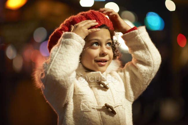 Menina, ao ar livre à noite, vestindo casaco e boina vermelha — Fotografia de Stock