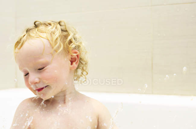 Niño jugando con agua en el baño - foto de stock