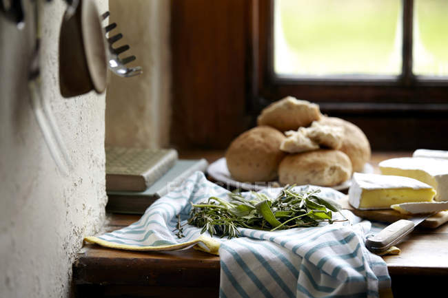 Bread rolls and brie cheese on kitchen counter — Stock Photo