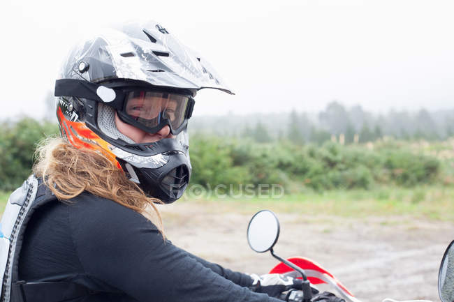 Retrato de médio adulto motociclista feminino no capacete de choque e óculos — Fotografia de Stock