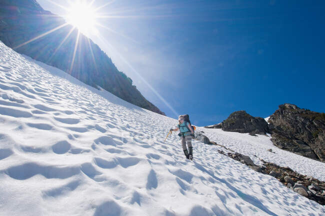 Женщина-альпинистка спускается с горы — стоковое фото