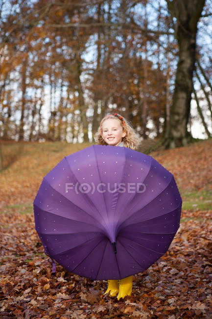 Chica jugando con paraguas en el parque - foto de stock