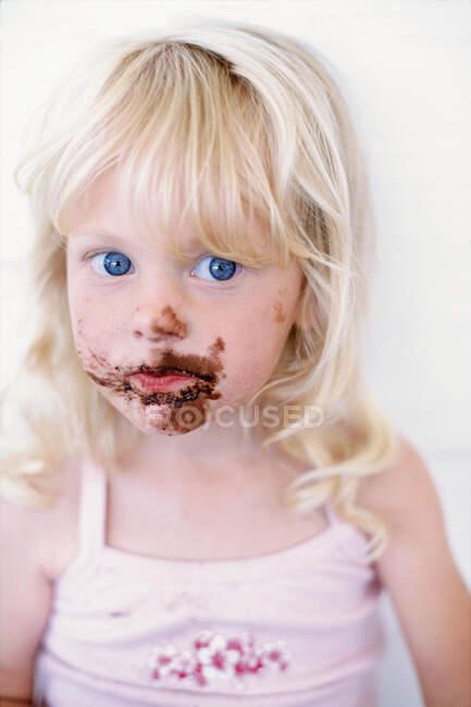Chica con chocolate en la cara - foto de stock