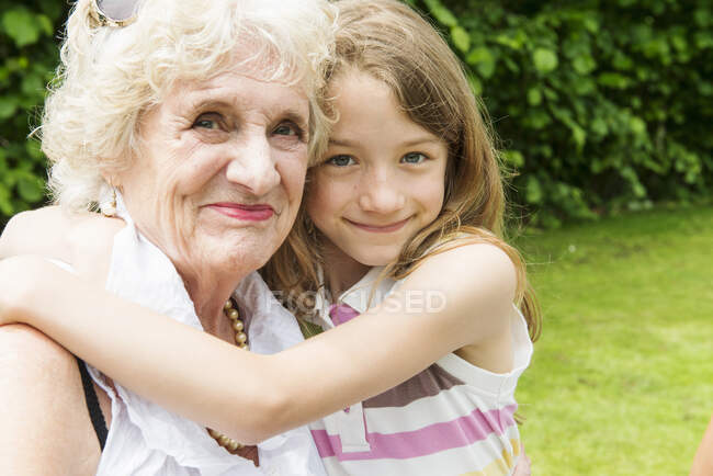 Retrato de la abuela y la nieta abrazándose - foto de stock