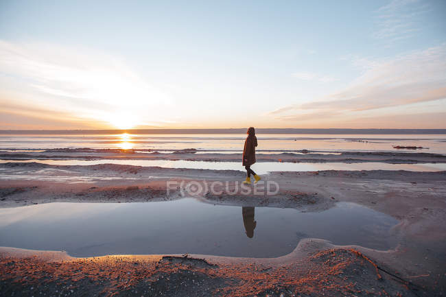 Femme profitant de la plage au coucher du soleil — Photo de stock