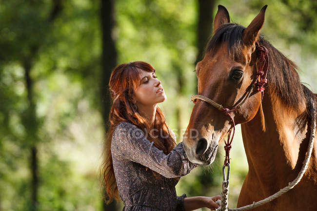 Woman walking horse in forest — Stock Photo