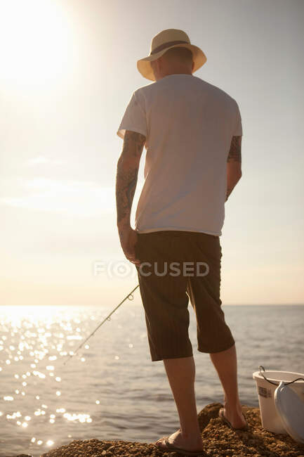 Homem pescando em mar calmo — Fotografia de Stock