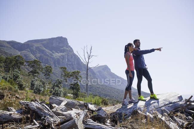 Jeunes joggeurs profitant de la vue depuis le sommet de la colline — Photo de stock