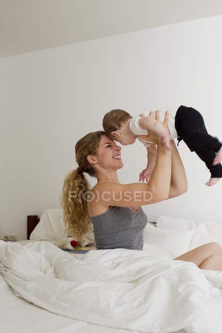 Mère tenant bébé garçon en l'air — Photo de stock