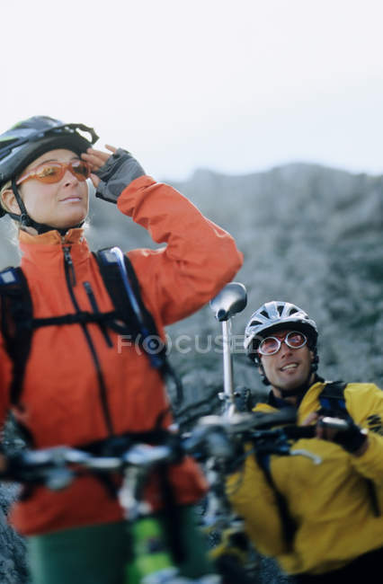Pareja de ciclistas de montaña mirando hacia otro lado - foto de stock
