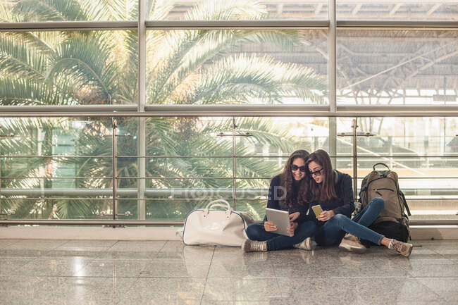 Дівчата-підлітки сидять на підлозі за допомогою цифрового планшета — стокове фото