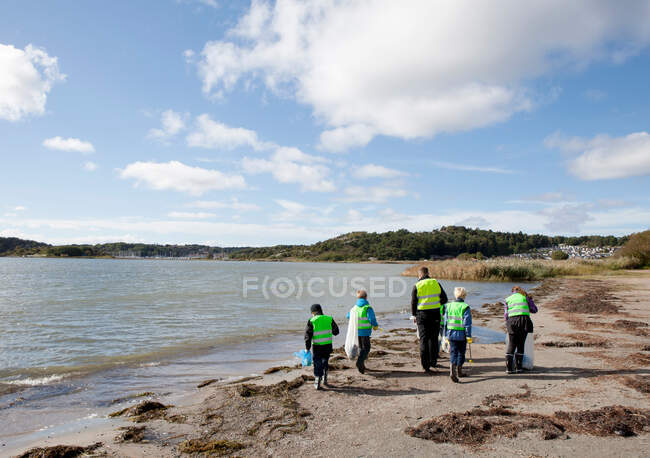 Ragazzi in giubbotti di sicurezza pulizia spiaggia — Foto stock