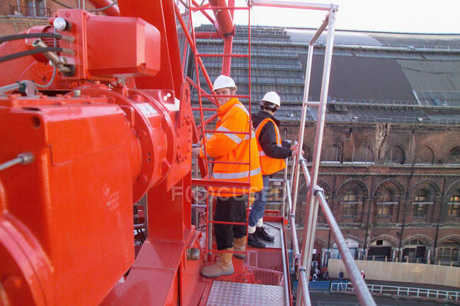 Men on crane at work site — Stock Photo