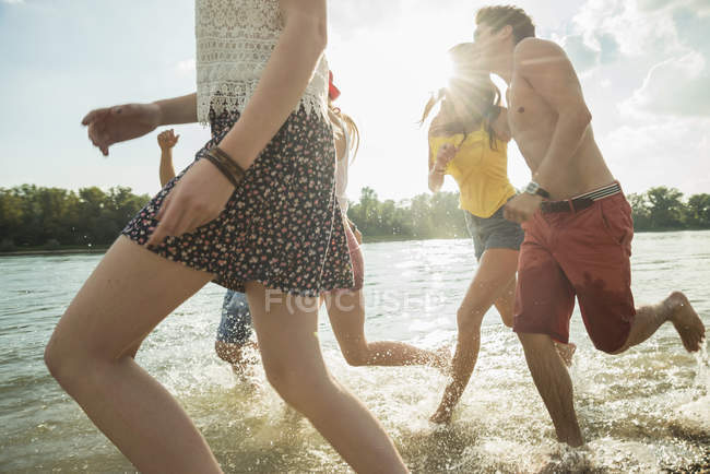 Группа молодых друзей, бегающих по озеру — стоковое фото