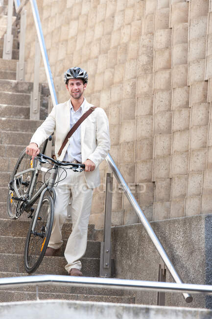 Молодий чоловік на сходах з велосипедом — стокове фото
