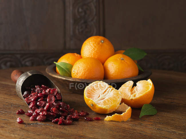 Whole and halved clementines with scoop of cranberries — Stock Photo