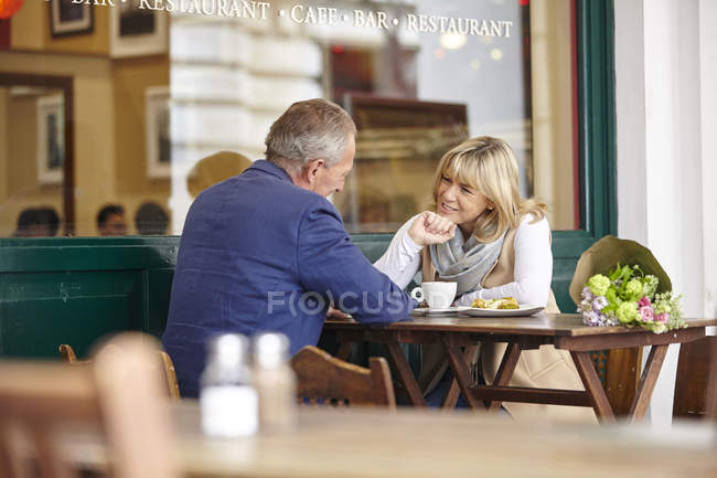 Mature sortir ensemble couple bavarder ensemble à la table de café trottoir — Photo de stock