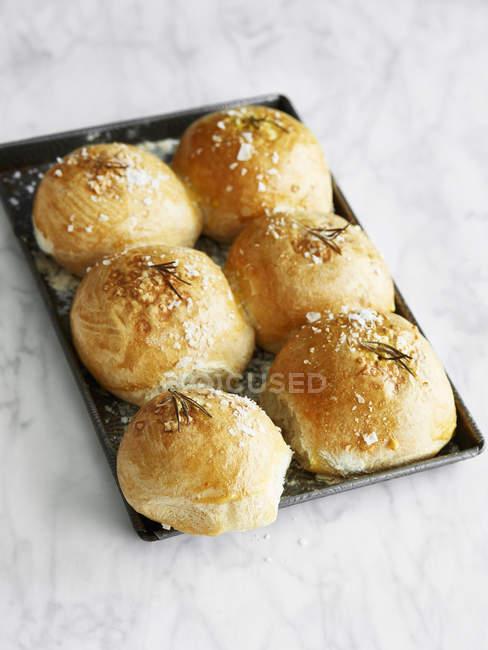 Fresh cooked bread rolls on baking tray — Stock Photo