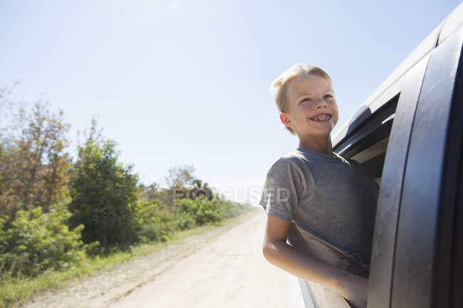 Boy having fun leaning out of truck window — Stock Photo