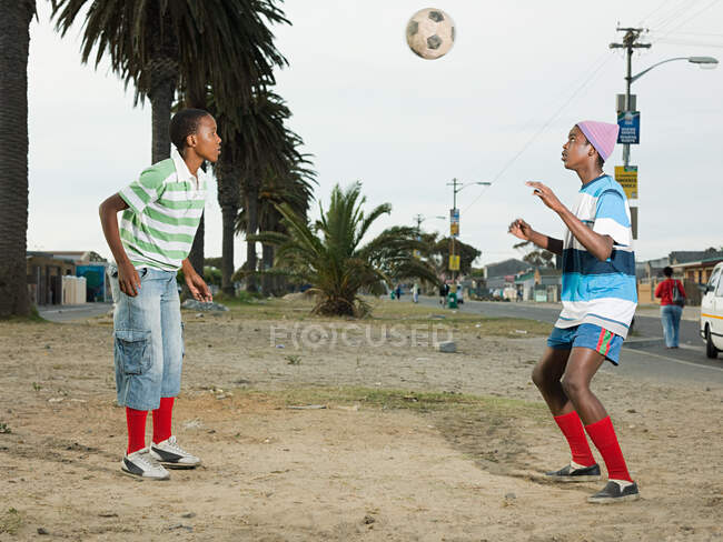 Chicos jugando al fútbol en la calle - foto de stock