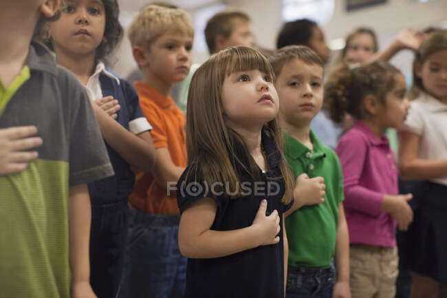 Niños recitando juramento de lealtad en la escuela - foto de stock