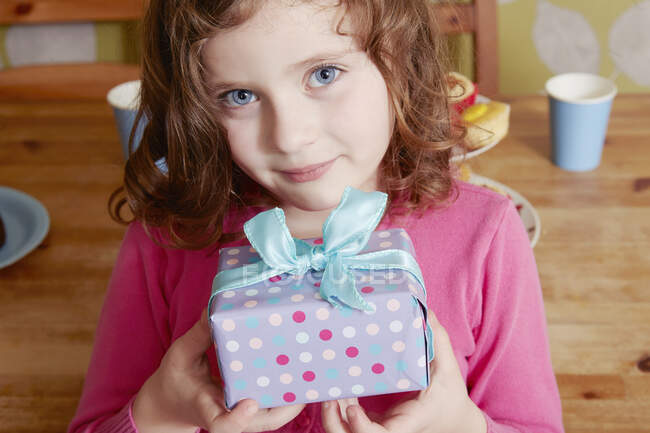 Portrait of girl holding birthday present — Stock Photo