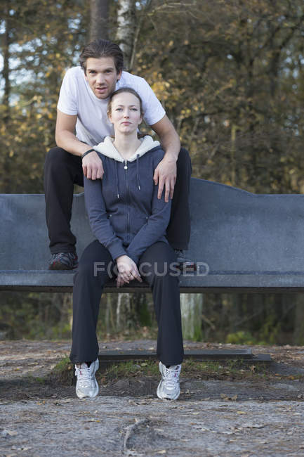 Paar sitzt auf Bank im Wald — Stockfoto