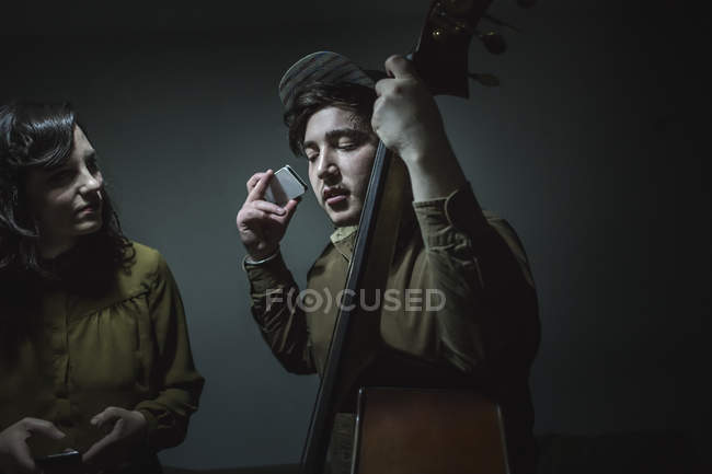 Musiker mit Kontrabass und Smartphone im Musikstudio — Stockfoto