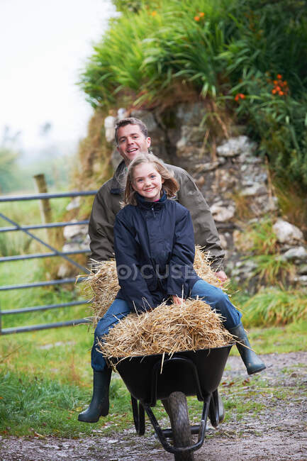 Girl being pushed in wheel barrow — Stock Photo