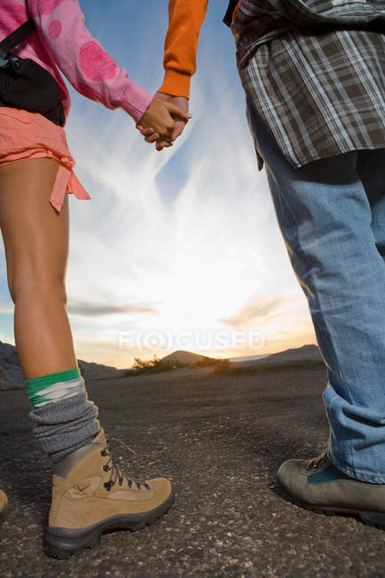 Rear view of man and woman holding hands, low angle — Stock Photo