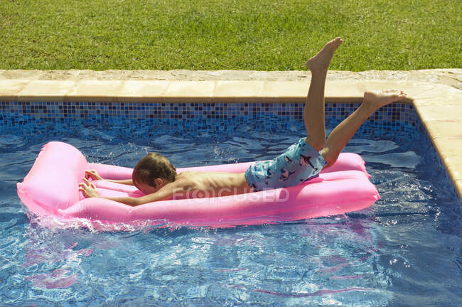 Um menino que mergulha em um inflável — Fotografia de Stock