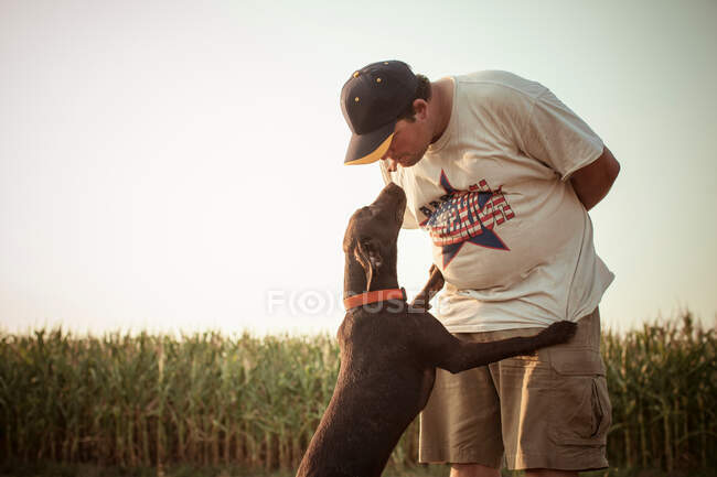 Homme embrasser labrador chocolat — Photo de stock