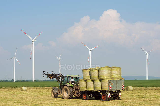 Wind turbines and harvesting machine — Stock Photo