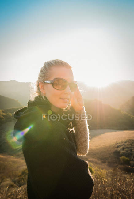 Жінка стоїть в пагорбі на сонячному світлі — стокове фото