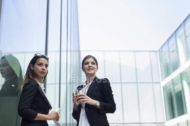 Businesswomen having lunch and ale in front of office building — Stock Photo